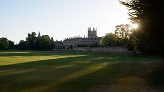 Christ Church in Oxford, view looking at the church with sunlight poking through the trees