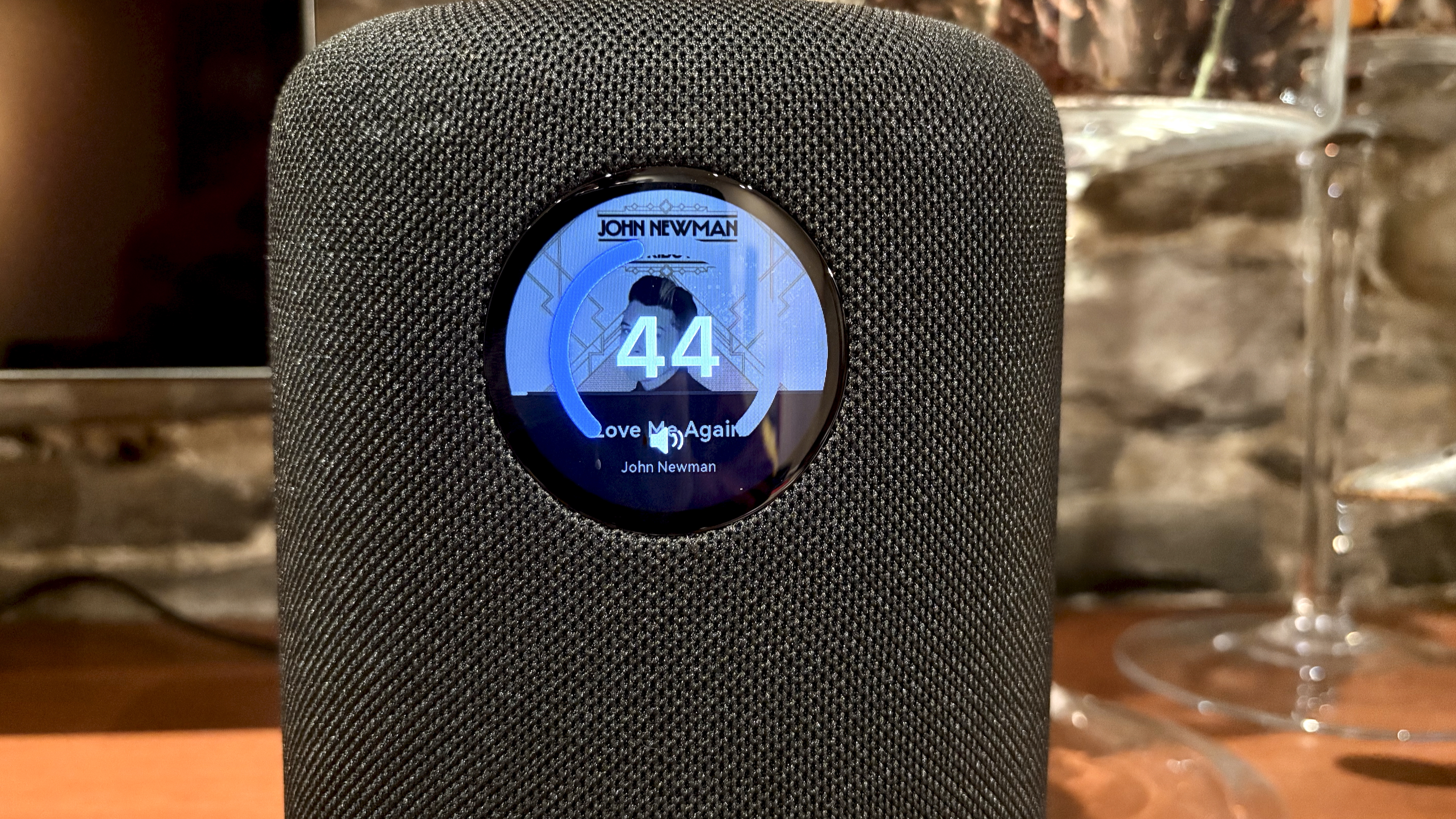 The WiiM Sound, in a home, on a varnished wooden table, showing the illuminated front panel