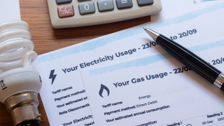 Gas and electricity paper bills with pen, bulb, and calculator