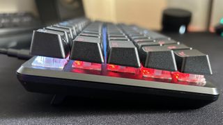Corsair K65 Pro Mini RGB side on showing keycaps and switches underneath, with RGB lighting on