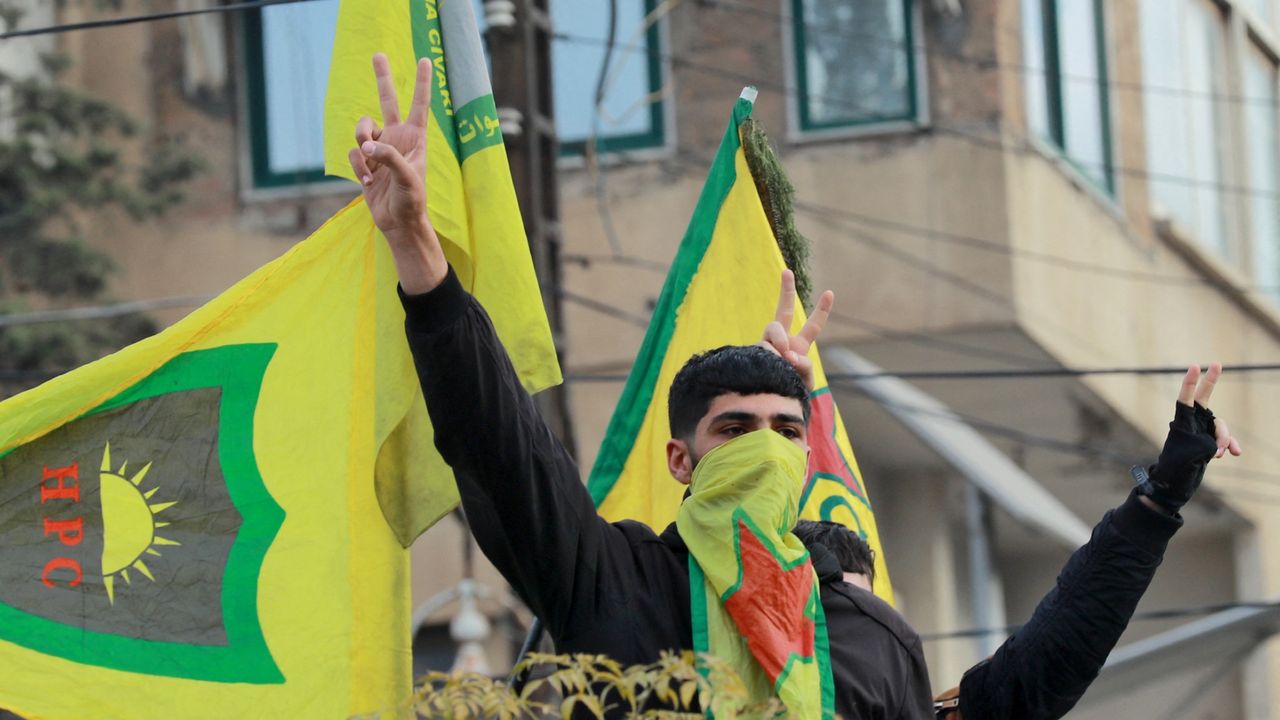 Syrian Kurds flash the V for victory sign as they celebrate the fall of capital Damascus to anti-government fighters, in the city of Qamishli on December 8, 2024. Islamist-led rebels declared that they have taken Damascus in a lightning offensive on December 8, sending President Bashar al-Assad fleeing and ending five decades of Baath rule in Syria. 