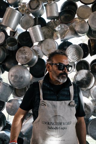 Indian artist Subodh Gupta surrounded by pans, staging a culinary performance work Cooking the World at the Hotel Cipriani in Venice for Mitico