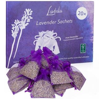 A stack of small purple bags filled with dried lavender in front of a purple cardboard box