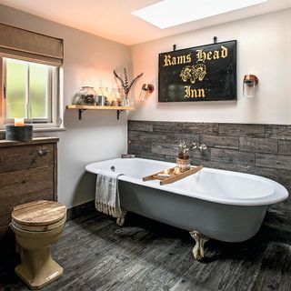 Bathroom with wooden paneling behind the bath tub