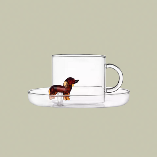 A glass cup and sauces with a glass dachshund figurine
