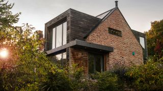 exterior of eco home with timber cladding, brick and a dormer extension