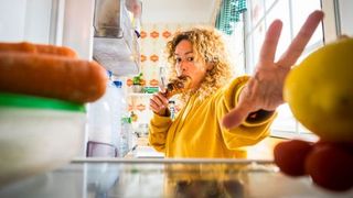 intuitive-eating-woman-reaching-into-fridge