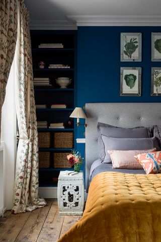 Blue bedroom with grey headboard and yellow bedspread