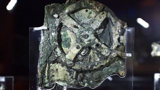 A photo of the corroded Antikythera mechanism in a museum