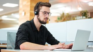 Man with laptop using microphone