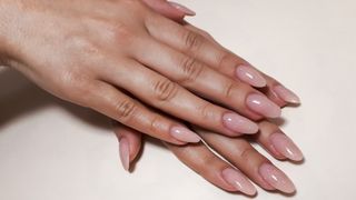 Hands with subtle, pink glossy manicure
