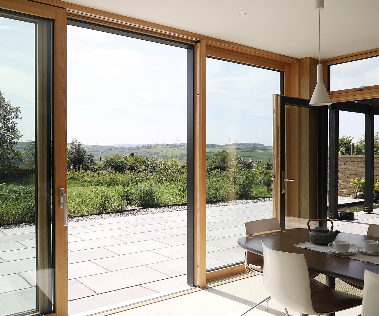 Large sliding doors leading outside to a paved patio areafrom a dining room