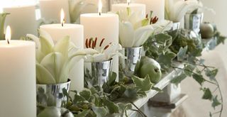 Close up of a Christmas mantel dressed with pillar candles and ivy