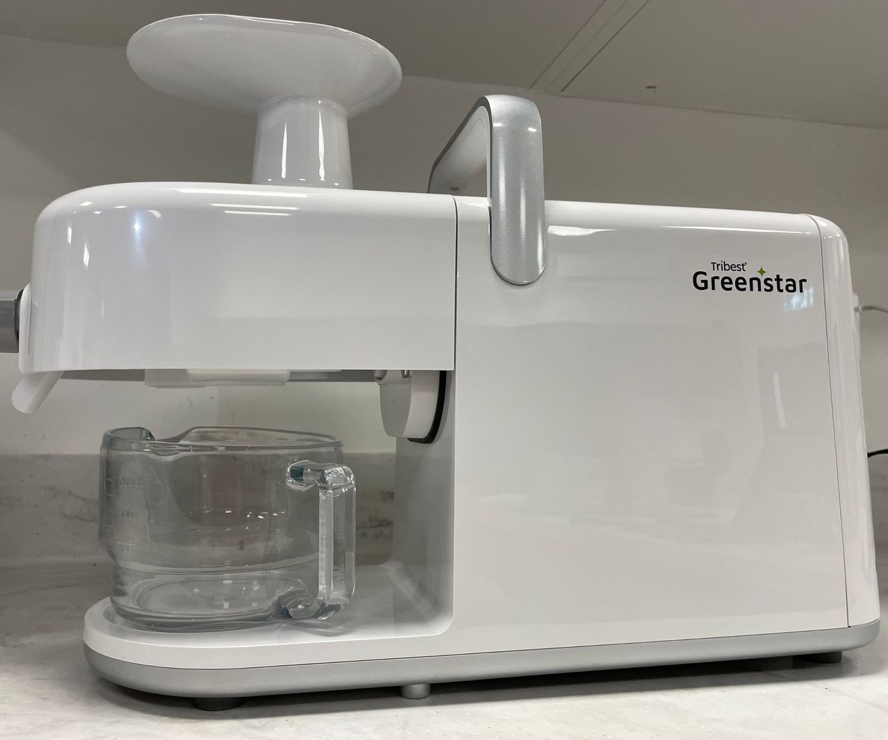 Tribest GreenStar 5 Juicer - a white plastic juicer with a horizontal design, on the countertop.