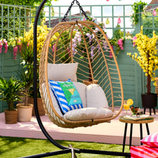 B&M Hampshire egg chair in a small garden. It has a margarita pillow to decorate.