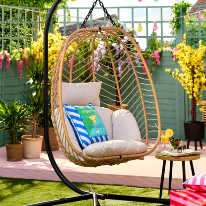B&M Hampshire egg chair in a small garden. It has a margarita pillow to decorate.