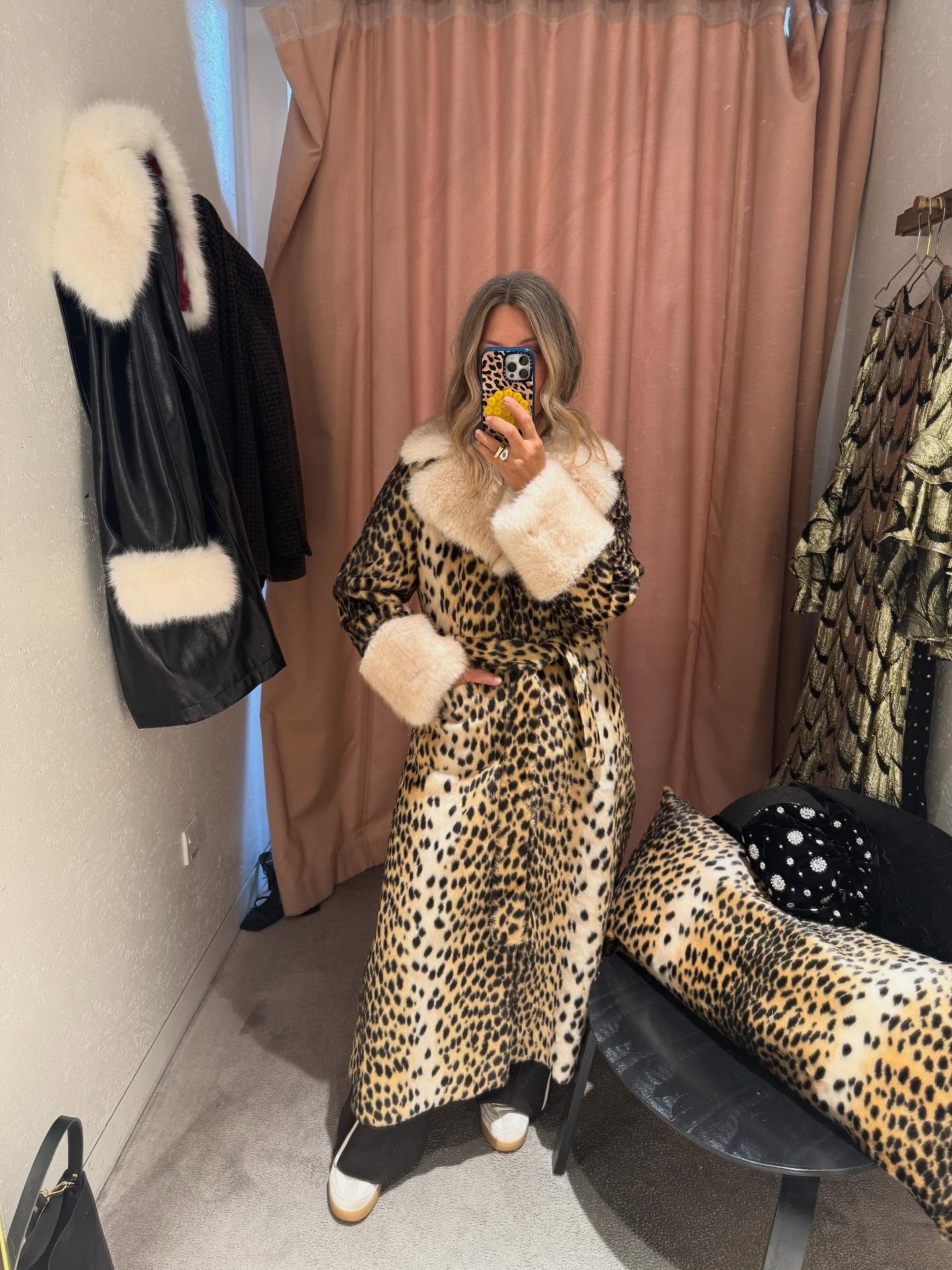 Influencer @erica_davies wears the Queens of Archive leopard print fur trimmed coat with black trousers and white trainers.