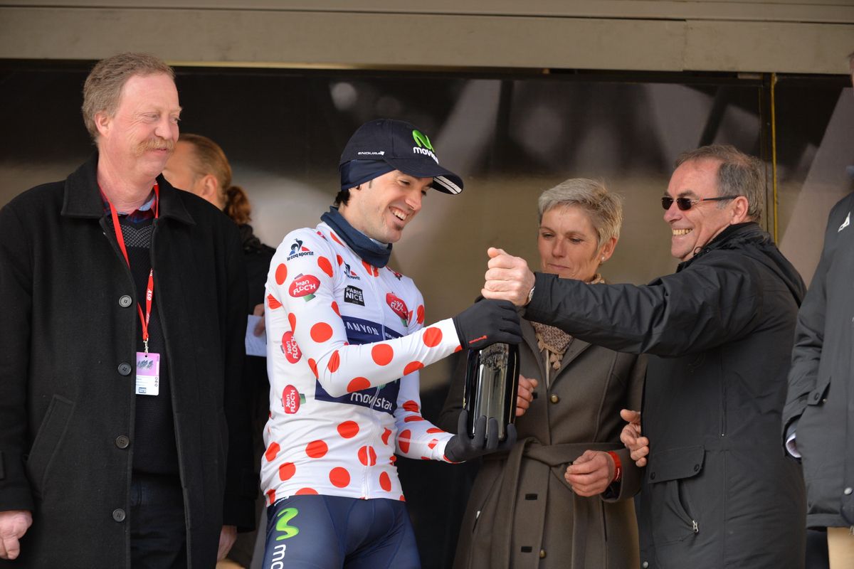 Ion Izaguirre (Movistar) is presented with a local bottle of wine by Bernard Hinault
