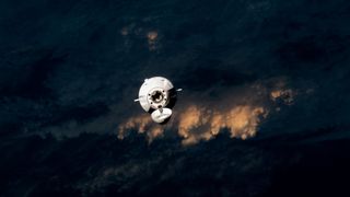 spacex dragon capsule approaches the international space station with earth's cloudy skies in the background