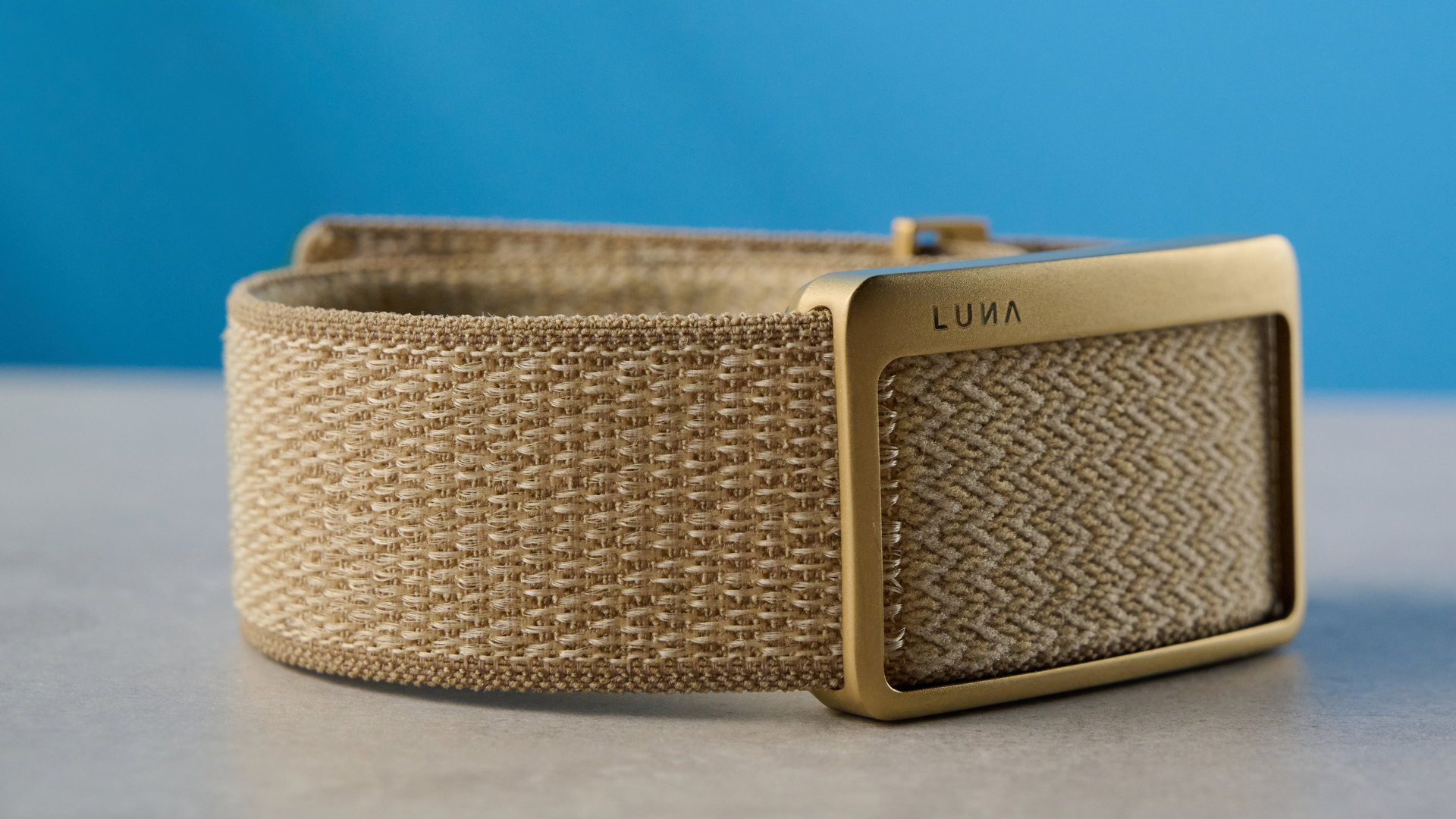 the luna band in beige photographed with the blue tom's guide background being worn by the author