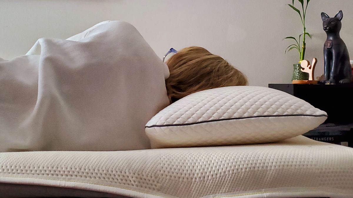 Our lead reviewer, Alison, takes a nap on her side to test out the Saatva Graphite Mattress Topper's cooling comfort
