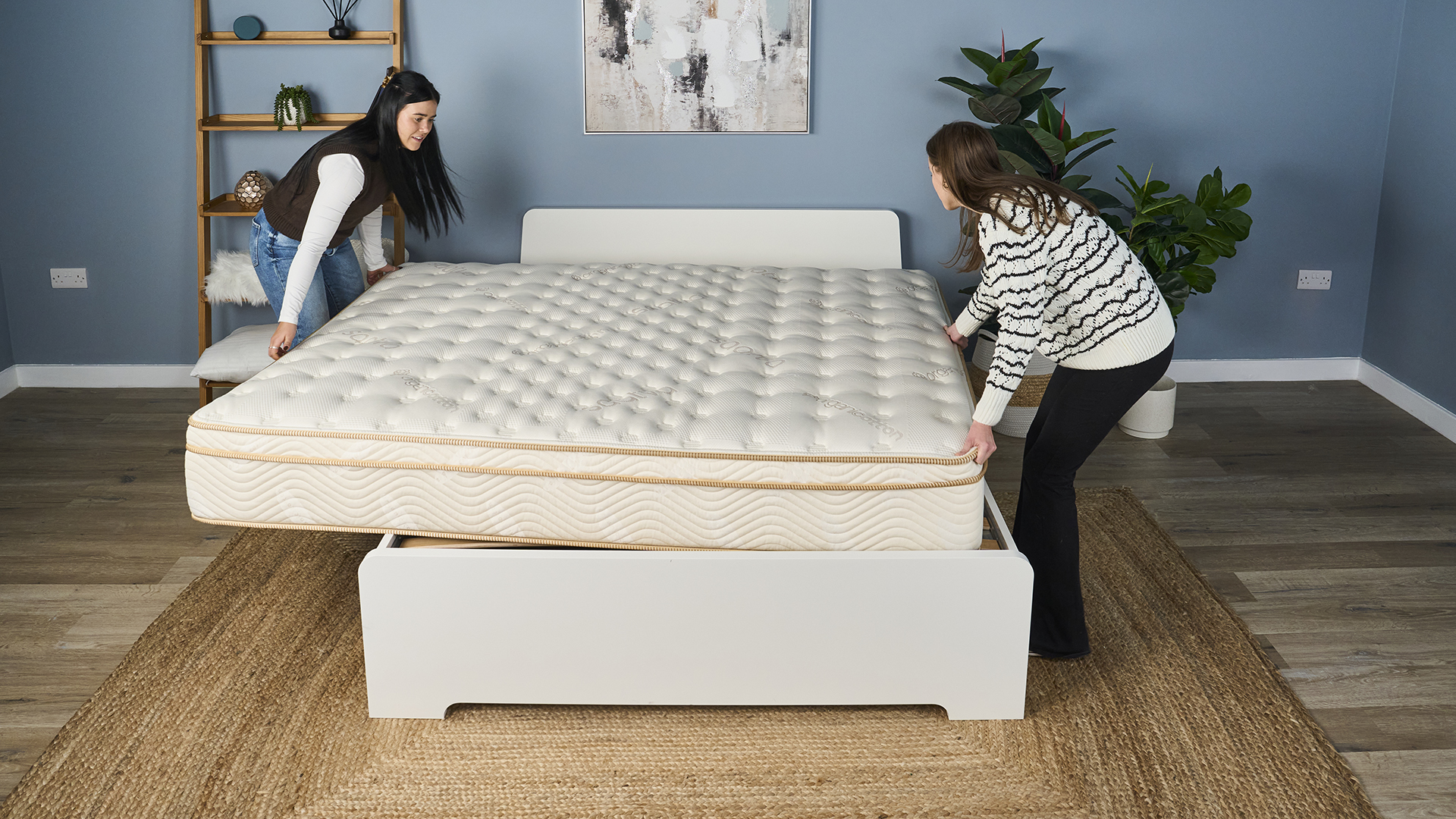 Tom's Guide Saatva Classic testers rotate the mattress on a white wooden bedframe