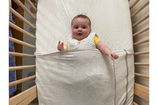 Baby Freddie in the ergoPouch Baby Tuck sheet while testing it out for this review