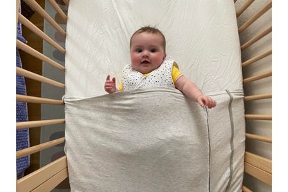 Baby Freddie in the ergoPouch Baby Tuck sheet while testing it out for this review