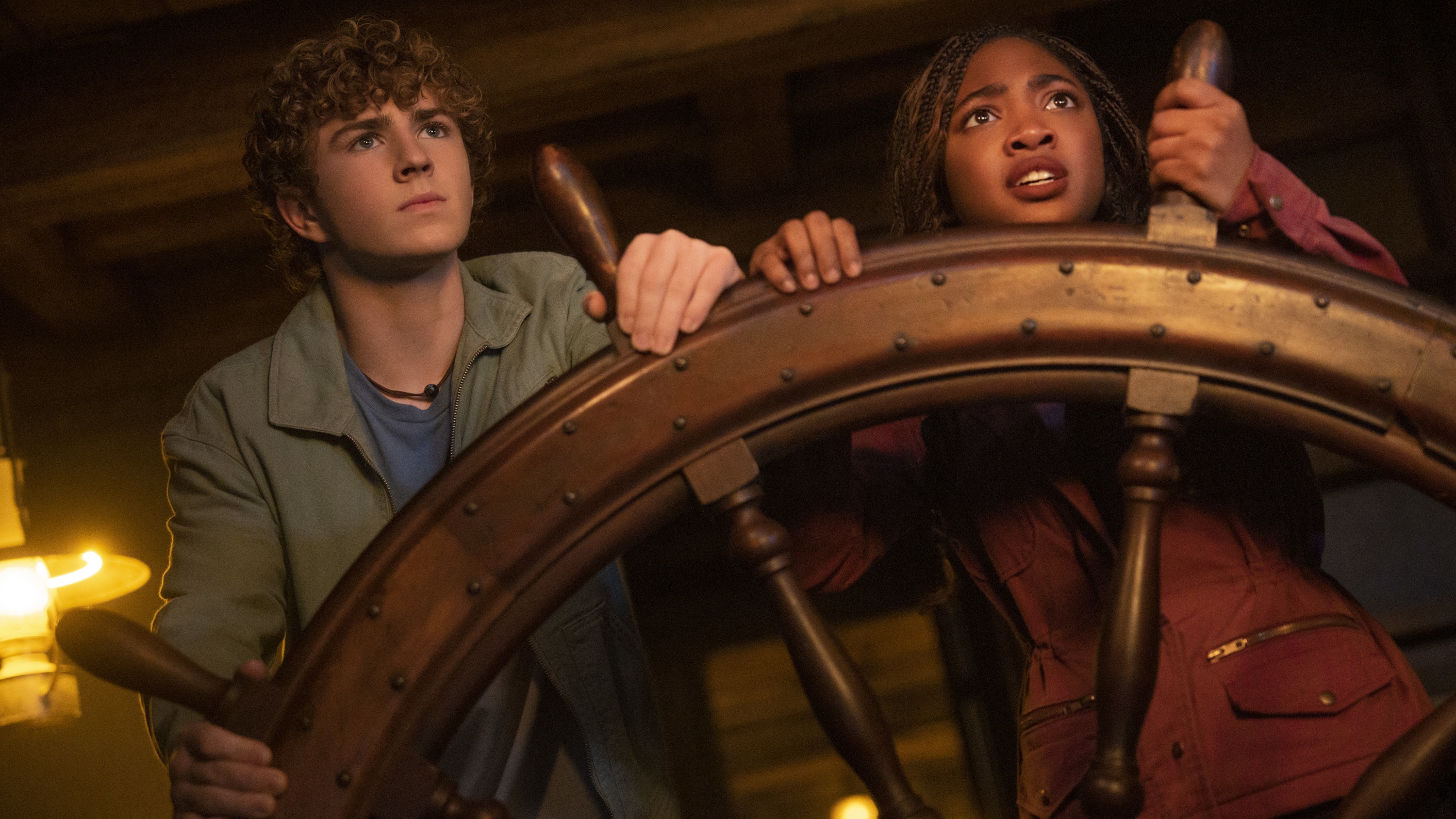 Percy Jackson and Annabeth Chase steering a ship wheel with concerned looks on their faces.