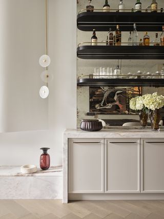 A white kitchen with brass patina mirror backsplash