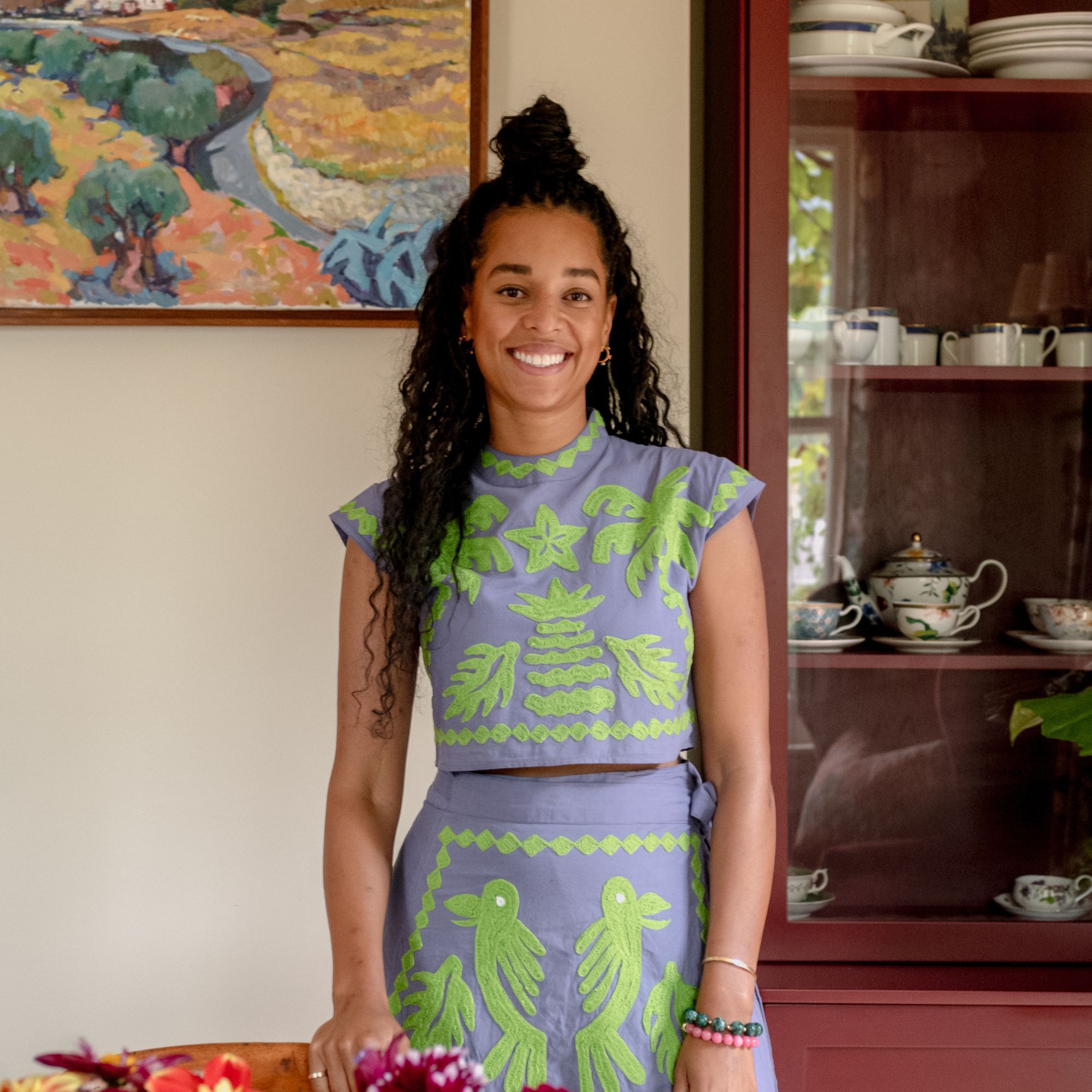 Micaela Sharp smiling at camera in purple-and-green dress