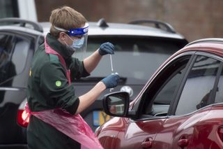 A health worker takes a swab for a COVID-19 test at Ashton Gate Stadium on January 11, 2021 in Bristol, England.