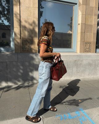 Woman in Marni sandals, Siedres top, and straight-leg jeans