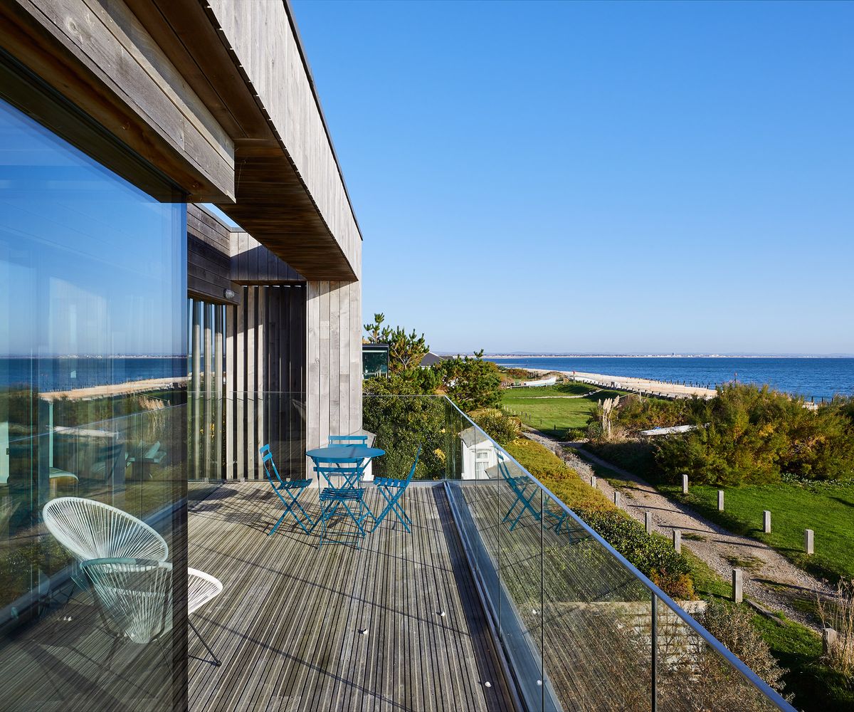 a balcony on a contemporary seaside property with views out to sea