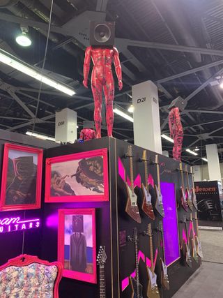 Guitars and figurines, displayed at Cream Guitars' 2023 NAMM show booth