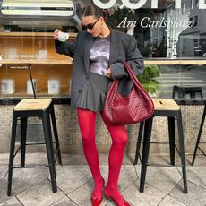 @lara_bsmnn wearing grey skirt, grey blazer, red tights, and red heels