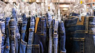 Rack of vintage denim blue jeans at antique flea market