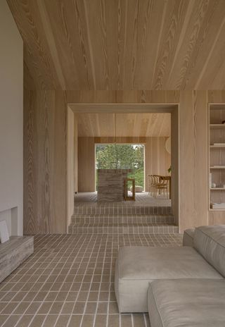 interior view with brick floor at Heatherhill Beach house by Norm Architects
