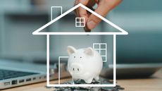 A hand dropping a coin into a piggy bank encased in a white line-art outline of a house