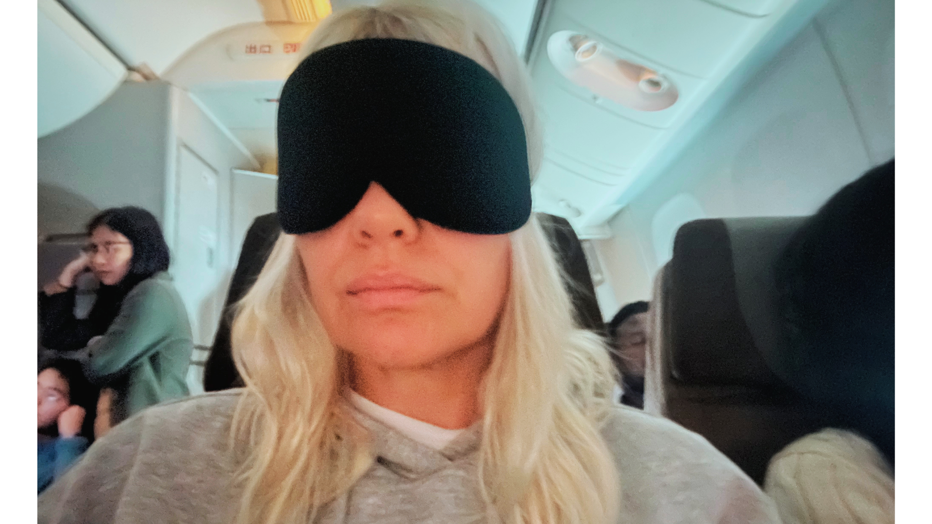Jenny Haward wearing her blackout eye mask on an airplane.