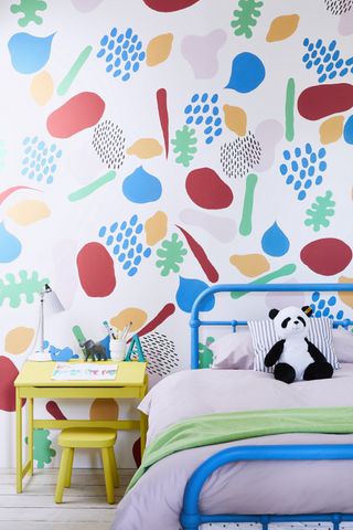 kids room with painted wall design, blue bed, yellow desk and stool