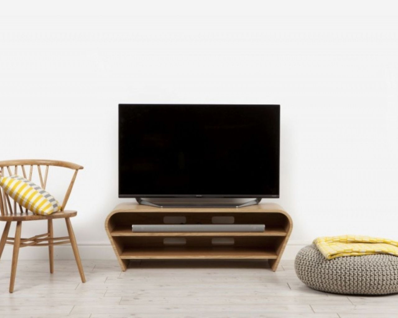 Tom Schneider Taper 1250 TV Stand in living room with chair and pouffe