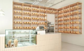 South korean bakery with till point, empty display case and loafs of bread on the shelving behind