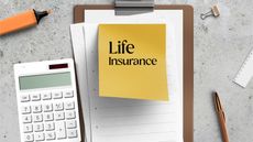 The words life insurance are written on a sticky note on top of a spiral notebook next to a calculator.