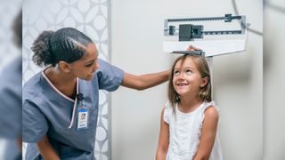 girl getting height measured at doctor's office