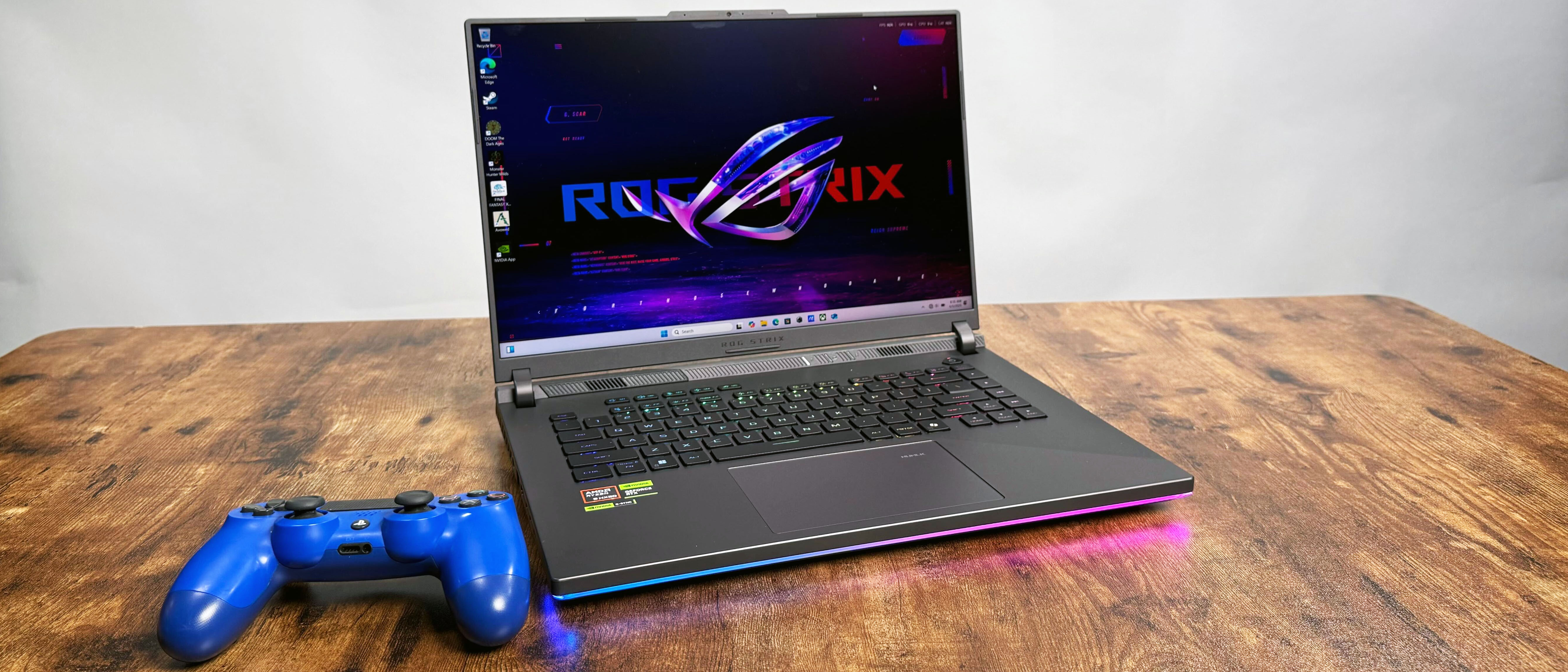 Asus ROG Strix G16 (G614FR) gaming laptop on a wooden desk against a gray background.
