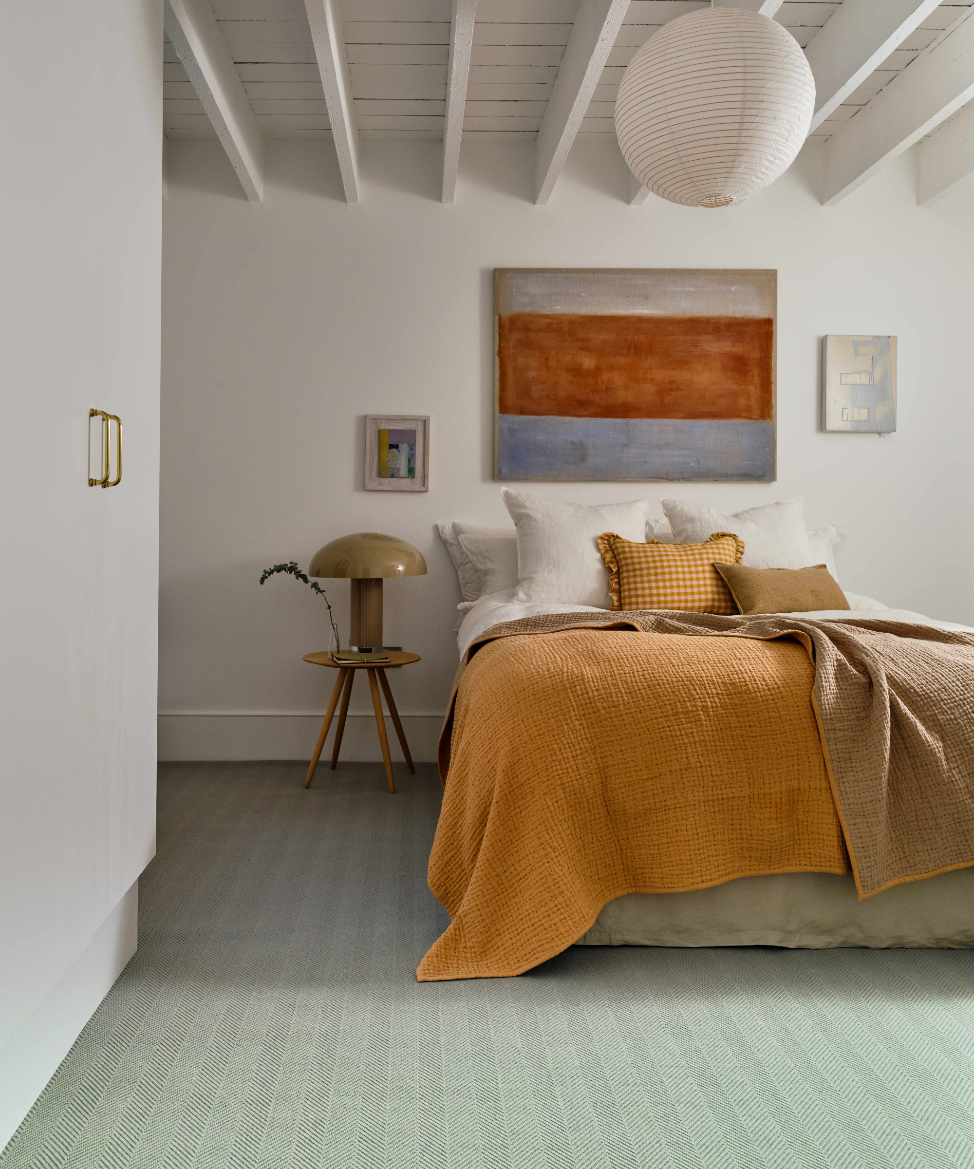 pale green carpet in bedroom with white beamed ceiling and simple decor