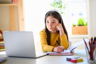 Girl studying at home with laptop donated for homeschooling