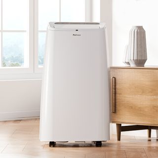 Pro Breeze 4-in-1 portable air conditioner and heater beside wooden cabinet