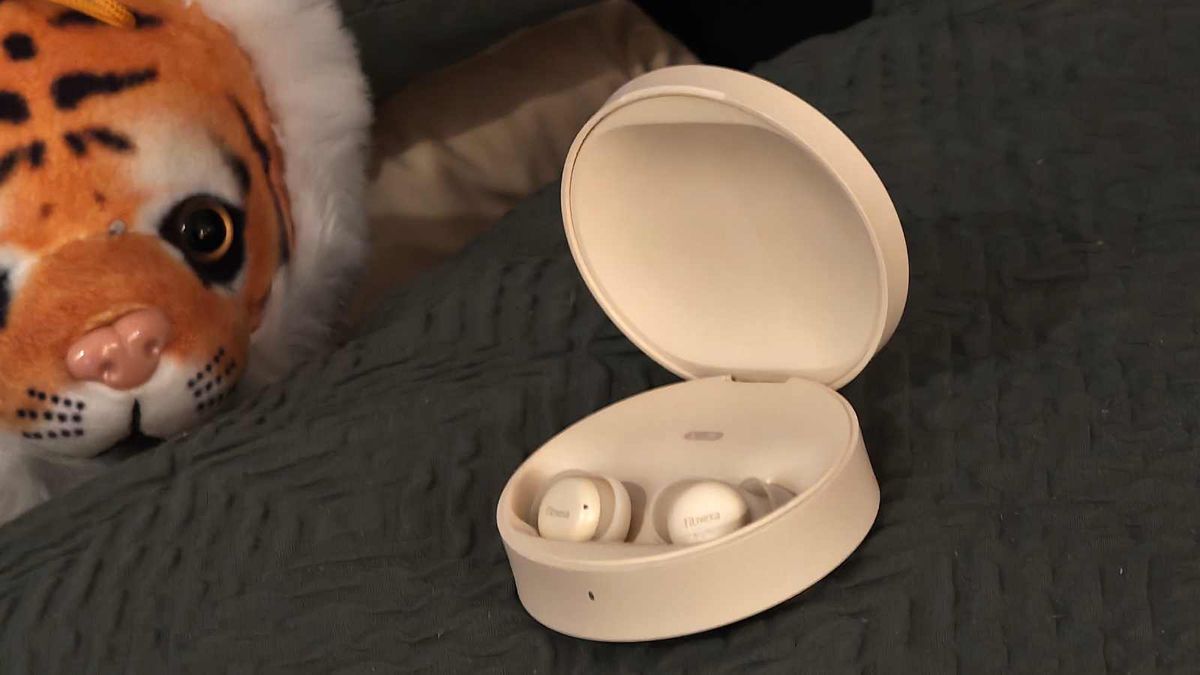 The Fitnexa SomniPods 3 on a pillow, with a stuffed lion examining it.